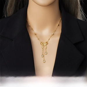 Détail du collier à pampilles nœud doré avec zircons gouttes sur mannequin en blazer