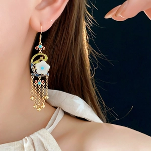 Detail of vintage flower tassel earrings with gold plating and enamel on model