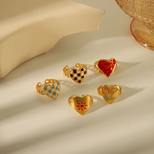 Set of five gold heart rings with enamel patterns and adjustable open bands