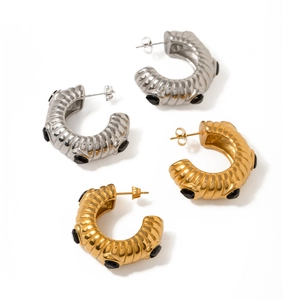 Elegant gold and silver C-shaped ribbed earrings with black zircon inlay on white backdrop