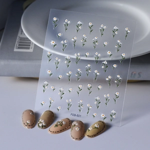 Close-up of 3D white daisy nail art stickers FEB-501 applied on nude nails