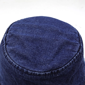 Gros plan d'un chapeau bob en jean bleu foncé montrant la texture sergé et les coutures