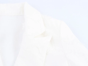 Dettaglio del colletto di un blazer bianco con frange e tessuto in tweed di qualità