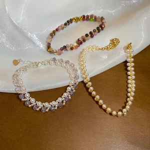 Elegant multi-layer beaded bracelets with pearls and agate stones on white silk fabric