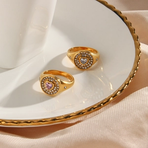 Close-up of gold-plated signet rings with pink heart zircon and micro-pave detailing