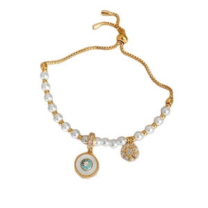 Bracelet ajustable en perles dorées avec pendentifs œil bleu et étoile sur fond blanc