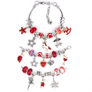 Detail of three DIY charm bracelets with red glass beads and silver unicorn pendants