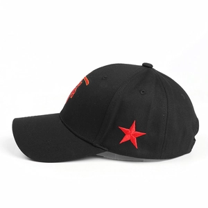 Detail view of red star embroidery on black cotton baseball cap with curved brim and stitching