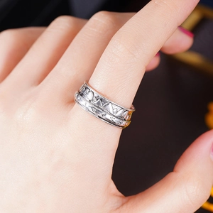 Detailed close-up of retro mountain range engraving on a wide silver metallic ring