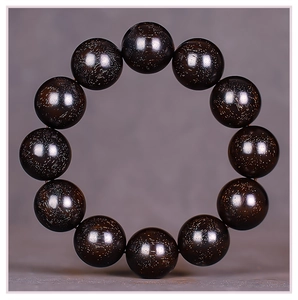 Macro shot of sandalwood beads with natural golden flecks and polished wood texture