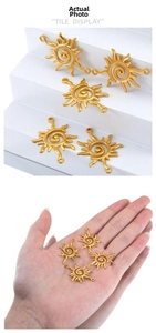 Detailed view of golden sun pendants with spiral texture and top loop for DIY jewelry making