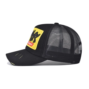 Detail of a vintage trucker hat featuring yellow 3D embroidery and distressed brim effect