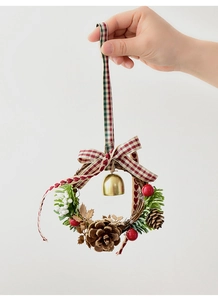 Mini Christmas wreath detail with pine cones, red berries, and festive plaid bow ribbon