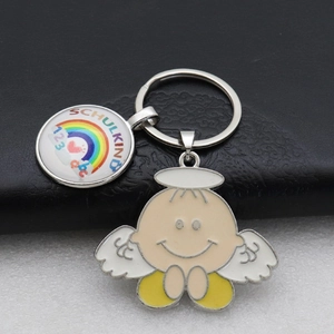 Detail of schoolkind rainbow keychain with cartoon angel pendant on leather background