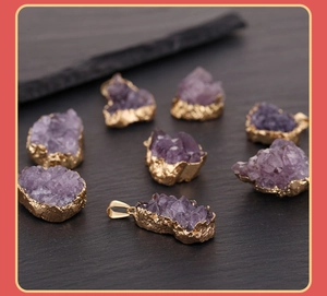 Macro detail of natural purple amethyst crystal pendants with gold plated edges