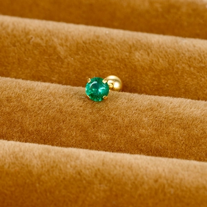 Macro view of green round zircon earring with gold 4-prong setting and ball back