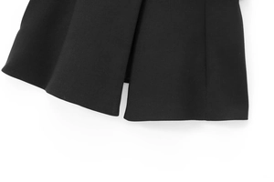 Détail de l'ourlet du gilet tissé noir avec coutures précises et fente latérale élégante