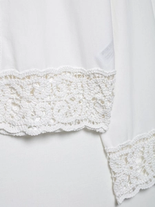 Gros plan sur la dentelle au crochet blanche et le tissu texturé de l'ensemble d'été