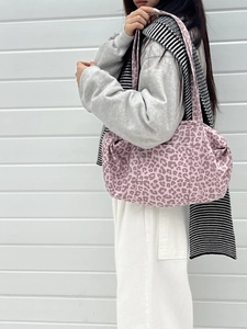 Borsa tote grande in pelle scamosciata maculata rosa da donna indossata a spalla da modella