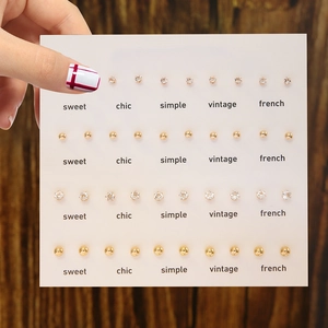 Set of 20 pairs of minimalist gold ball studs and sparkling zircon earrings on a display card
