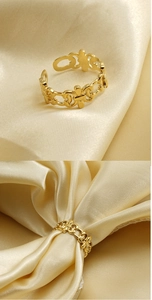 Close-up of vintage hollow gold-plated adjustable ring with intricate engraved floral patterns