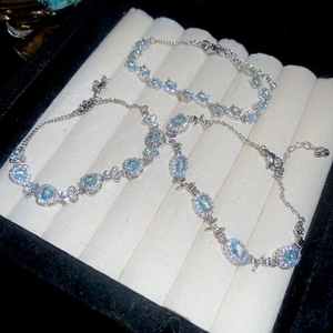 Close-up of aquamarine zircon bow bracelets on white velvet jewelry display box