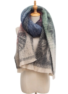 Detailed view of bouclé yarn texture and ginkgo leaf pattern on a fringed scarf