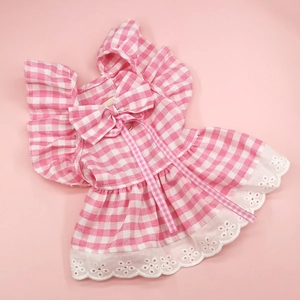 Detail of pink plaid pet dress featuring a cute bow and white embroidered lace hemline