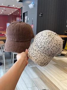 Detail showing distressed cotton fabric texture on brown and leopard print baseball caps