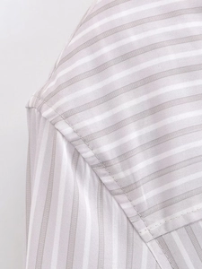 Close-up of fine grey striped fabric showing high-quality stitching on shoulder and cuff