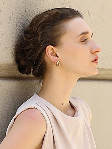 Primo piano di eleganti orecchini a cerchio placcati oro 18K con perle indossati da modella