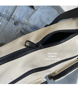 Detail of durable beige canvas bag featuring black plastic zipper and contrast stitching