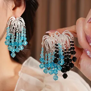 Luxury long fringe earrings with blue glass beads and silver chains on a female model