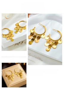 Detail of gold circle hoop earrings featuring hanging metallic disk tassels in high polish