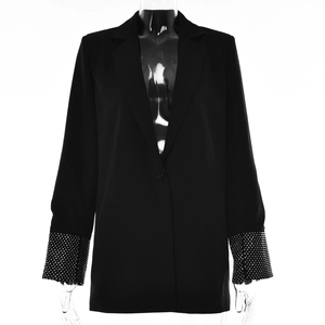 Dettaglio del blazer nero con paillettes luccicanti e cristalli sui polsini delle maniche