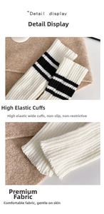 Detail view of white knitted leg warmers featuring elastic ribbed cuffs and black stripes