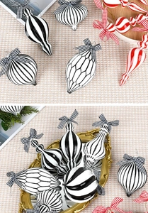 Detail of red, black, and white striped glass ornaments with checkered bows for tree decor