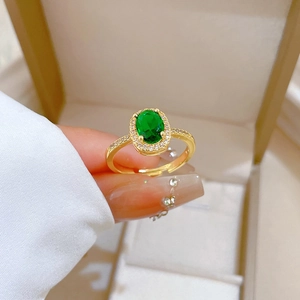 Elegant adjustable gold ring with oval emerald gemstone and halo diamonds on band