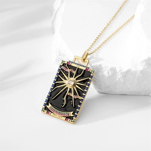 Macro detail of gold tarot sun pendant with colorful zircons and engraved Roman numerals