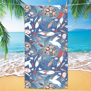 Large microfiber beach towel featuring ocean sea turtle and narwhal print on sandy beach
