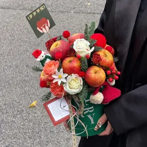Christmas apple flower box with white roses and pine branches in a green round hug bucket