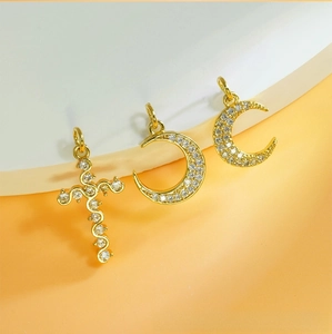Detailed view of gold plated crescent moon and cross pendants with micro pave zircon
