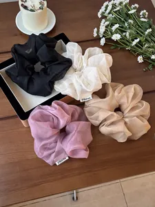 Dettaglio di grandi elastici per capelli in organza in vari colori su base di legno
