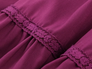 Dettaglio dell'abito boho con pieghe in tessuto fucsia e ricamo in pizzo delicato