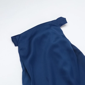 Détail d'une robe élégante en satin bleu marine montrant la coupe et la texture