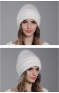 Detailed knit texture of white winter rabbit fur beanie shown on a model's head
