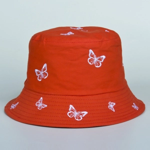 Detail of red cotton bucket hat featuring white butterfly embroidery and twill texture