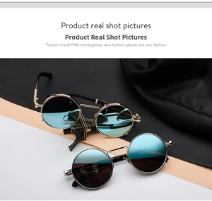 Detail of steampunk flip-up round sunglasses with gold metal spring temples and blue lenses