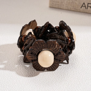 Close-up of ethnic beaded bracelet with carved wood flower and coconut shell beads