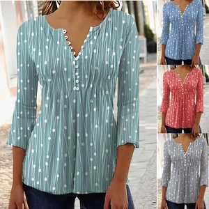 Detailweergave van damesblouse met V-hals en verschillende artistieke geometrische patronen